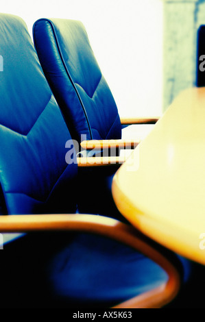 Ledersessel und ein Holztisch in einem leeren Sitzungssaal. Stockfoto