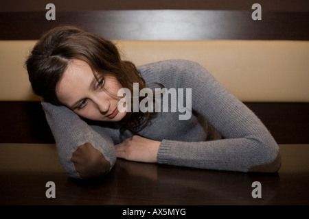 Junge Frau beugte sich über den Tisch in einer Bar, auf der Suche deprimiert Stockfoto