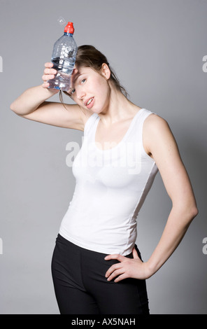 Erschöpfte junge Frau nach einem Workout mit Wasserflasche in der hand Stockfoto