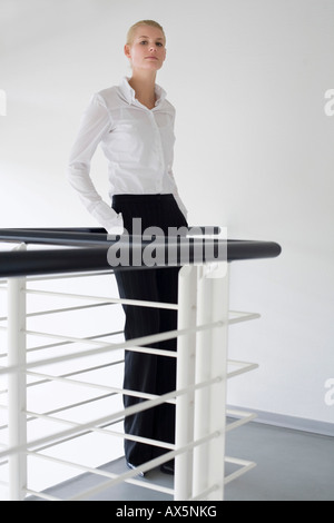 Blonde Unternehmerin ein Geländer gelehnt Stockfoto