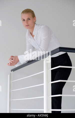 Blonde Unternehmerin ein Geländer gelehnt Stockfoto