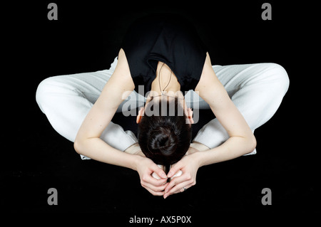 Ballett-Tänzerin, die sitzen auf dem Boden tun stretching-Übungen Stockfoto