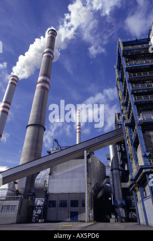 Pocerady, Tschechische Republik. Kraftwerk mit rauchenden Schornsteinen vor blauem Himmel mit weißen Wolken. Stockfoto