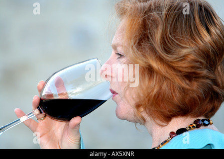 Junge Frau trinkt ein Glas Rotwein Stockfoto