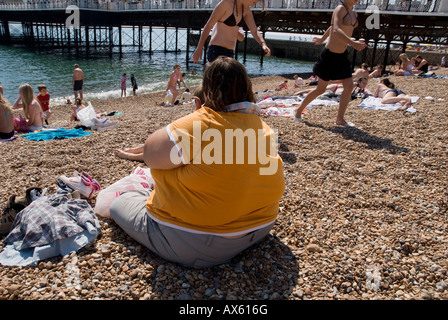 Eine große Frau liegt am Strand von Brighton Stockfoto