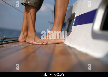 Paar auf Deck eines Segelbootes, Fokus auf Füßen Stockfoto