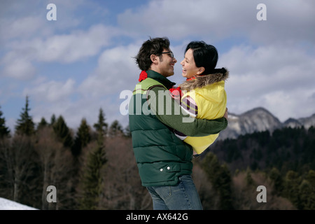 Junger Mann tragenden lachende Frau Stockfoto