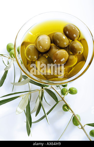 Frische grüne Oliven und Olivenöl in Glasschale Stockfoto