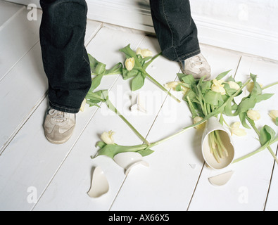 Zerbrochene Vase und Blumen am Boden Stockfoto