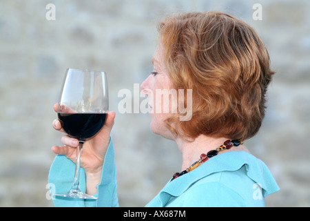 Junge Frau trinkt ein Glas Rotwein Stockfoto
