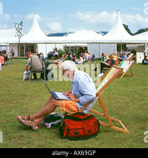 Ein älterer Mann sitzt in einem Liegestuhl mit seinem Laptop auf das Hay-Festival, Hay-on-Wye Wales UK KATHY DEWITT Stockfoto