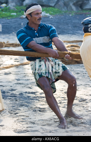 Männer ziehen in Fischernetze am Strand von Varkala Indien Stockfoto