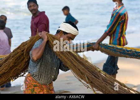 Männer ziehen in Fischernetze am Strand von Varkala Indien Stockfoto