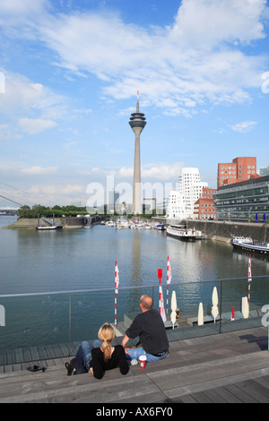 Menschen entspannen am Yachthafen mit Rhinetower im Hintergrund. Düsseldorf. Nordrhein-Westfalen, Deutschland, Europa Stockfoto