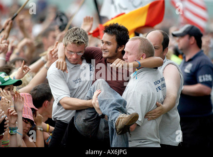 Sicherheit dazu ein Fan von der Masse in die Grube bei T im Park Music festival Stockfoto