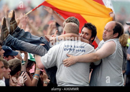 Sicherheit dazu ein Fan von der Masse in die Grube bei T im Park Music festival Stockfoto