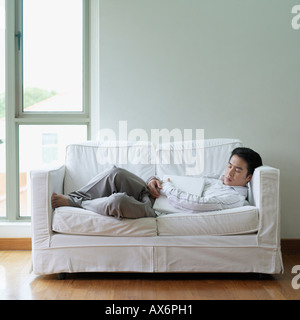 Seitenansicht eines jungen Mannes auf einer Couch schlafen Stockfoto