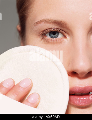 Frau mit Luffa-Pad im Gesicht Stockfoto