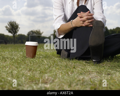 Frau sitzt im park Stockfoto