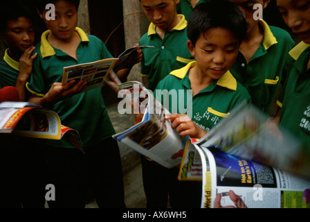 Chinesische Kinder Pause eine Zeitschriften an der Ta Gou Akademie in Shaolin anschauen Stockfoto