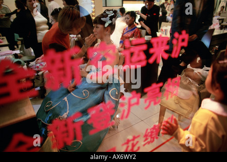 Eine Braut und Bräutigam bekommen ihr Haar und Make-up gemacht bei Hochzeit Fotostudio auf Hua Hai Lu In Shanghai Stockfoto