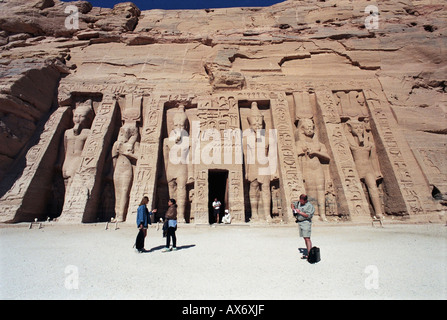 Touristen, die in den Schatten gestellt durch kolossale Statuen von Ramses II, der Hathor Tempel der Königin Nefertari, Abu Simbel, Ägypten Stockfoto