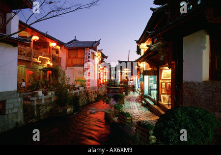 Geschäfte und Restaurants entlang einem Stein gepflasterten Straße in Lijiang in der Nacht, Lampions von den Geschäften hängen Stockfoto
