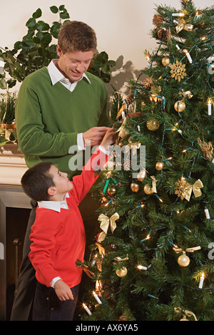 Vater und Sohn einen Weihnachtsbaum Dekoration Stockfoto