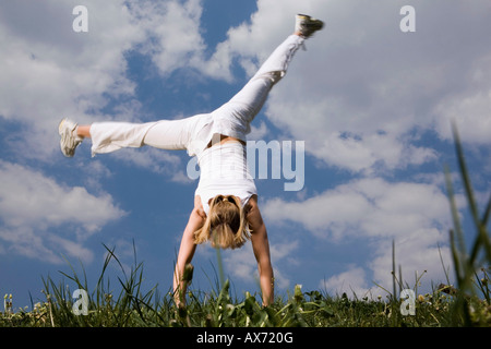Junge Frau macht Kopfstand Stockfoto