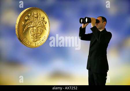 Mann im Anzug, Blick durch ein Fernglas in Richtung UK Pfund-Münze Stockfoto