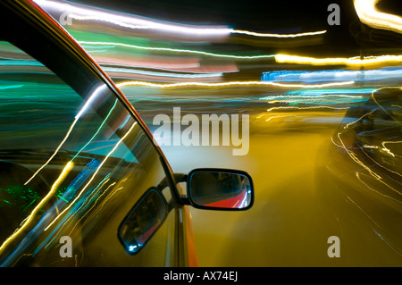 Nächtliche Fahrten mit unscharfen Lichtstreifen in Zeitlupenaufnahmen, nächtlichen fotografischen Effekten und Techniken, Stockfoto