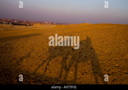 Silhouette von Reisenden Kamelreiten, die Pyramiden von Gizeh, Ägypten zu besuchen. Stockfoto