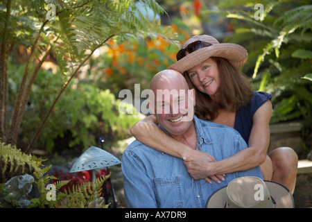 Porträt einer reifen Frau, die einen Reifen Mann von hinten umarmen Stockfoto