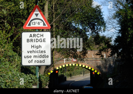 Niedrige Bogenbrücke Warnzeichen und gut sichtbare Markierungen auf Schiene Brücke, Cheam, Südlondon, Surrey, England Stockfoto