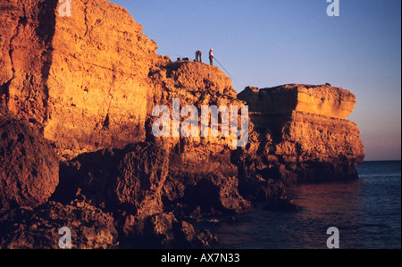 Sao Rafael Strand in der Nähe von Albufeira, Algarve, Portugal in der roten Abendsonne mit den Fischern auf der Klippe Stockfoto