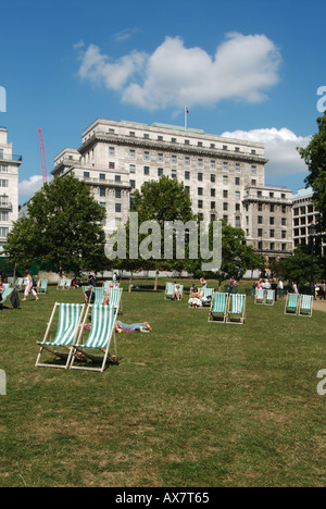 Green Park in London Wochentag zur Mittagszeit Büroangestellte und Touristen entspannen in und um Liegestühle Stockfoto