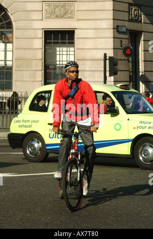 Der Londoner Bank Kreuzung Radrennfahrer mit Taxi Cab jenseits Stockfoto