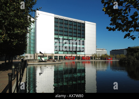 Global Switch Datacenter-Anbieter Moderne Räumlichkeiten in East India Docks East London England Großbritannien mit roten Bussen und Reflektionen in landschaftlich gestaltetem Wasser Stockfoto