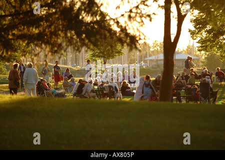 Eine große Gruppe von Menschen sammeln in einem Park am Abend sehen Sie ein Community-event Stockfoto