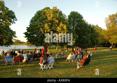 Eine Gruppe von Menschen sammeln in einem Park am Abend sehen Sie ein Community-event Stockfoto