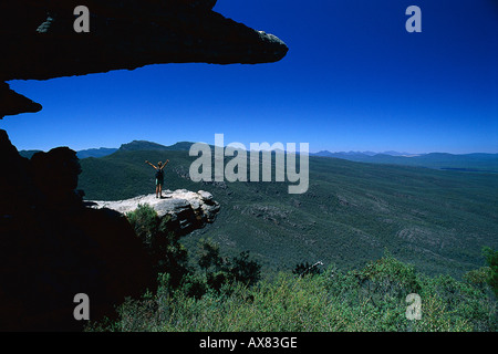 Eine Frau steht auf einem Felsvorsprung unter blauem Himmel, die Balkone, Reeds Lookout, Serra Range, Grampians National Park, Victoria, Au Stockfoto