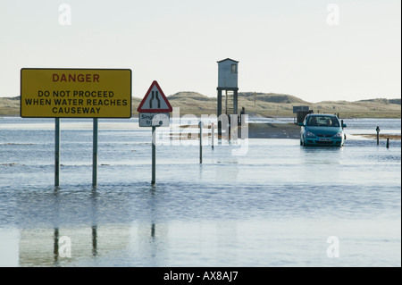 Ein Auto auf den Damm verbindet heilige Insel auf das Festland, Northumberland, England gestrandet Stockfoto