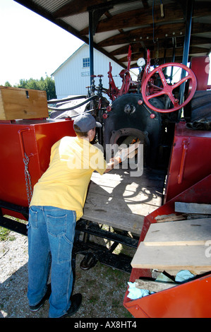 Teenager teilt Holzscheite für den Einsatz in laufen einen Dampfantrieb Traktor Stockfoto