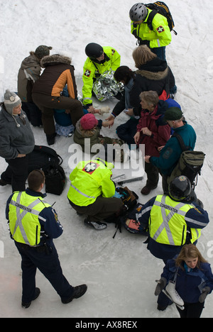 Medizinisches Personal kümmern sich um Kinder verletzten Fuß auf dem Rideau Canal Skateway während Ottawa Canadas jährlichen Winterlude festival Stockfoto