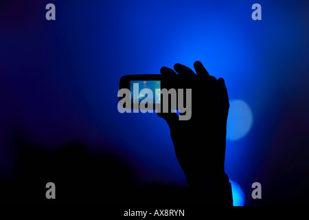 Hand in der Luft in der Masse unter video mit einem Mobiltelefon bei einer Tanzveranstaltung in Belfast, Northern Ireland Stockfoto