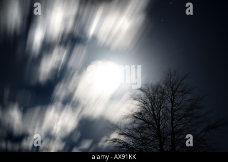 Mond (in der Frühlings-Tagundnachtgleiche) peeping Out hinter schönen Wolken. Bewegung ist die Bewegung der Wolken über längere Exposition Stockfoto