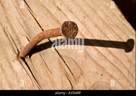 Rostigen Nagel in einem alten verfallenen Stück Holz Stockfoto