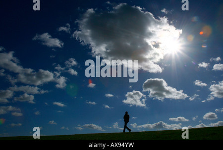 Ein Mann geht entlang einer Kante Silhouette gegen den Himmel auf der South Downs Way in Sussex im Touristenort in Südengland Stockfoto