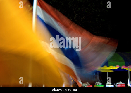 die Dharma-Rad-Flagge des thailändischen Buddhismus und rot, blau und weiß, die Nationalflagge von Thailand in einem Abendbrise verschwimmen Stockfoto