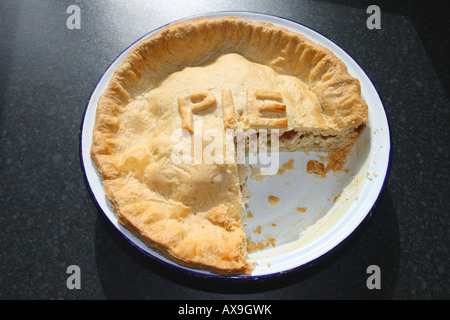 "Ein gekochtes Hühnerfleisch Pie mit dem Wort"Pie"in Gebäck Buchstaben auf der Oberseite und ein Teil entfernt, in eine Kuchenform auf der Küchenarbeitsplatte" Stockfoto